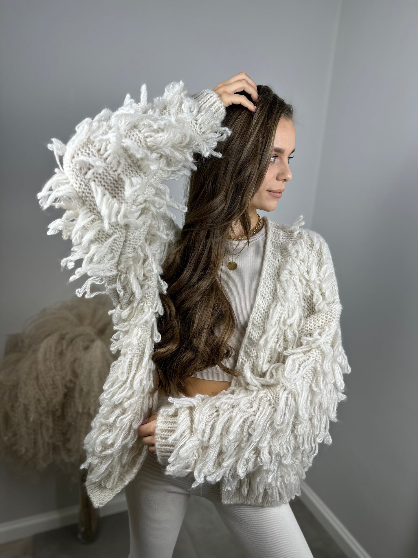Sweter z frędzlami podkreślający nieformalny charakter stylizacji