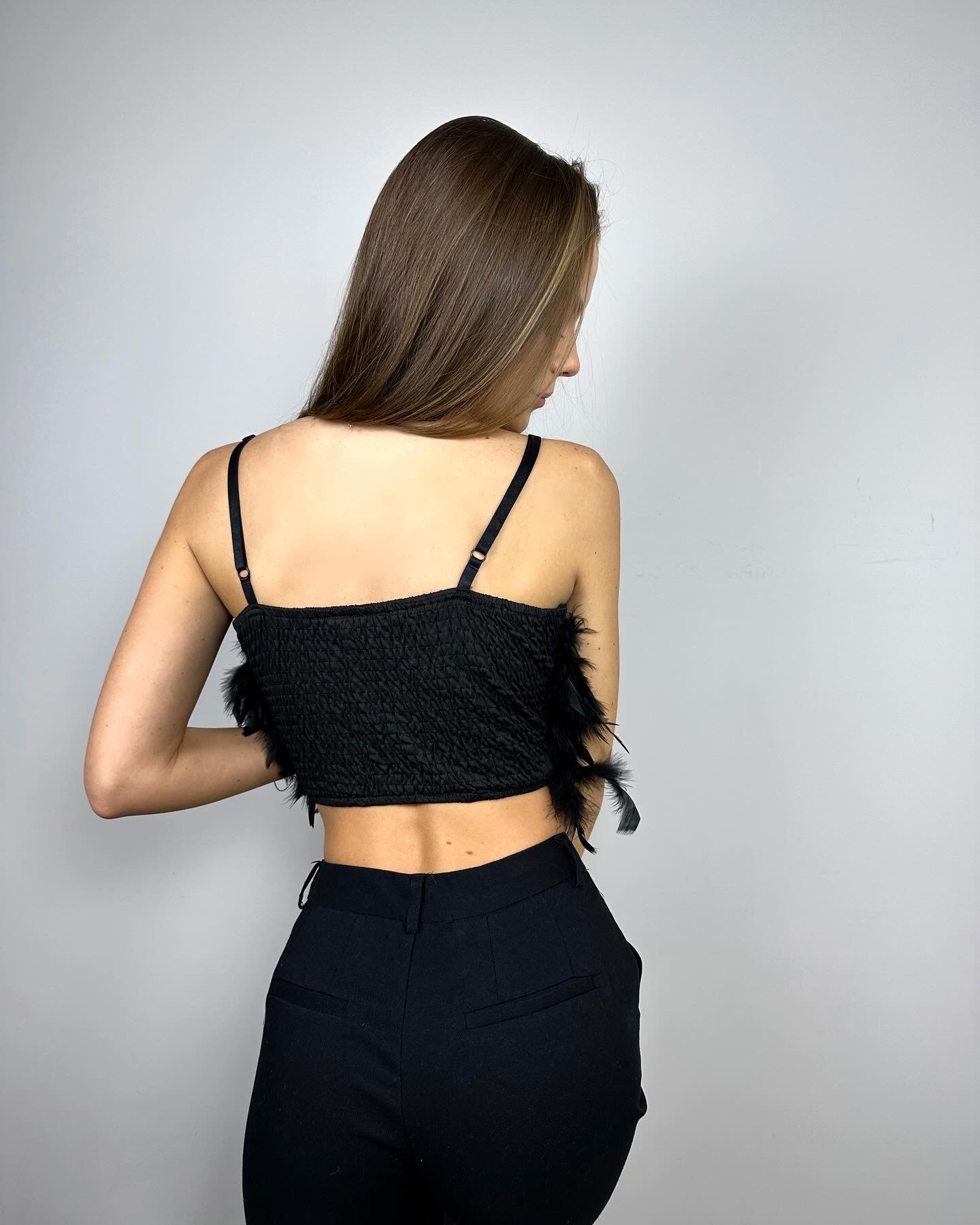 Czarny top z piórami podkreślający elegancki look